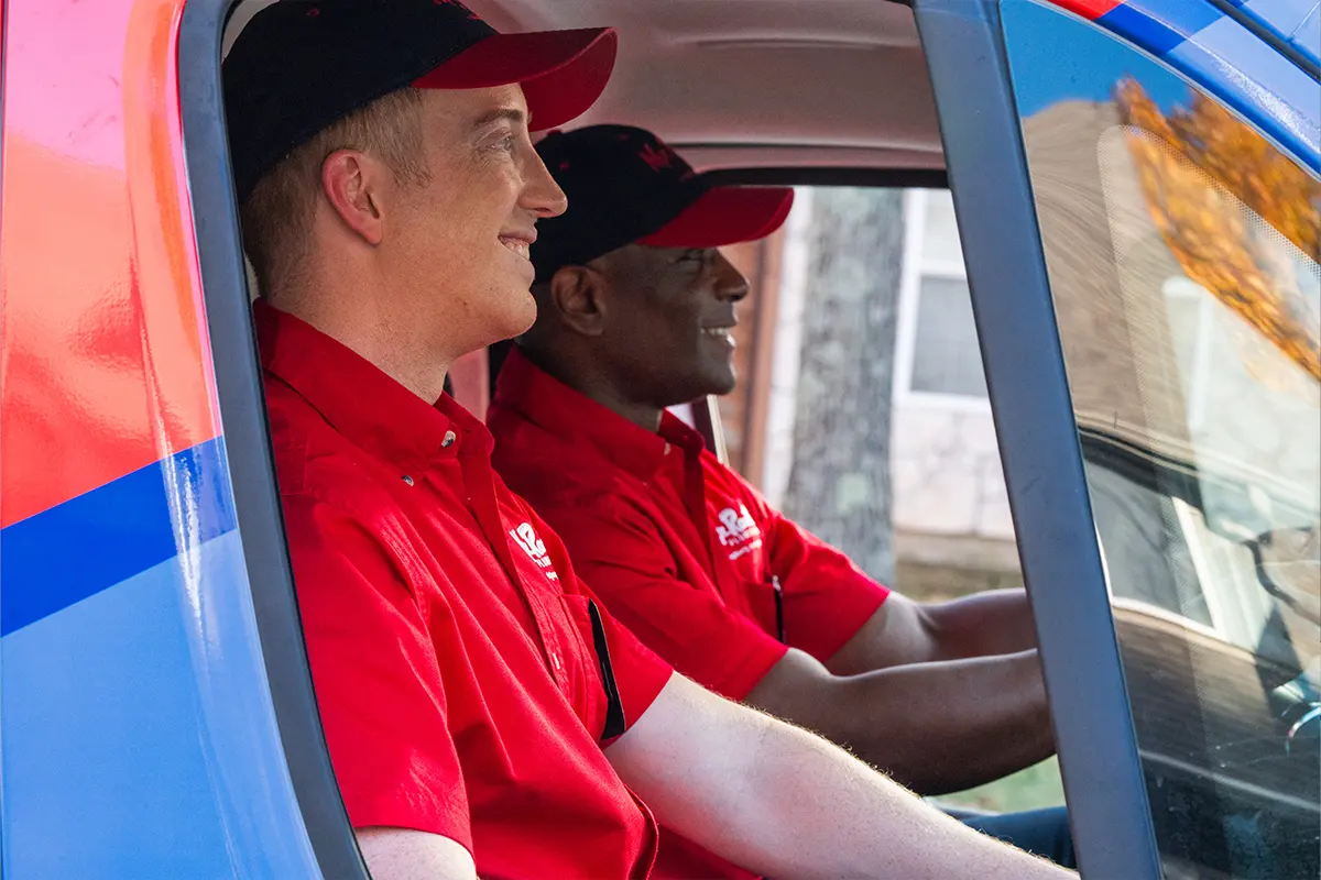 Two plumbers from Mr. Rooter Plumbing in a truck.