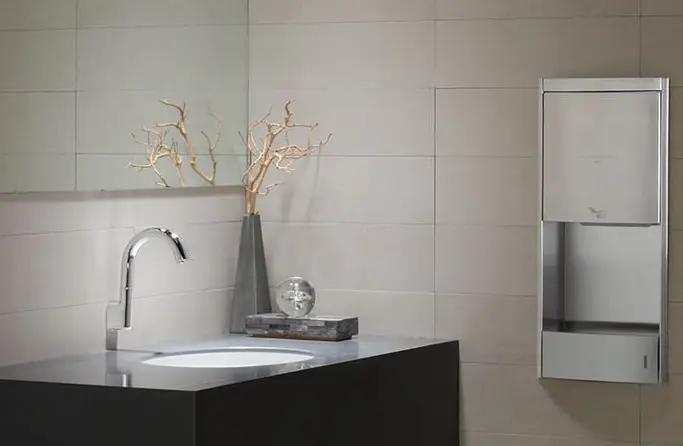 A commercial restroom with a hands-free faucet.