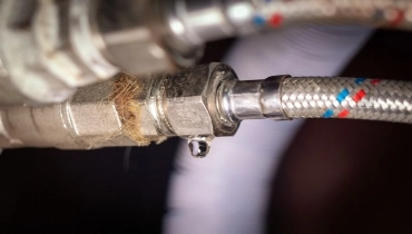 A drop of water leaks from a plumbing hose. | Mr. Rooter Plumbing of Virginia Beach