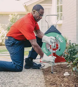 Mr. Rooter Technician using a drain snake