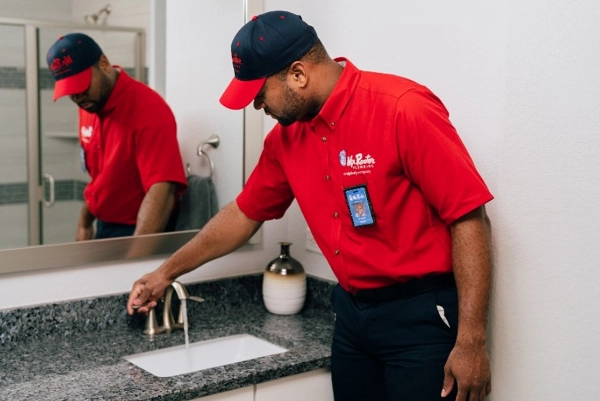 Mr. Rooter plumber tests water pressure