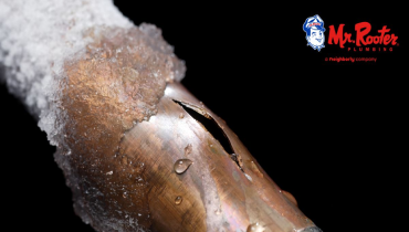 Copper pipe with frost and ice on it and a crack in the middle.