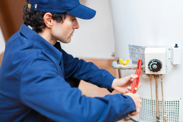 Plumber using a wrench to repair a water heater