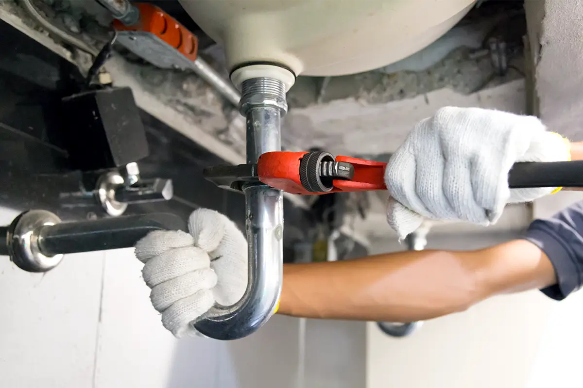 A person investigating plumbing problems in a home