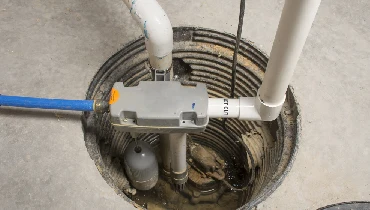 A sump pump installed in a basement of a home with a water powered backup system.