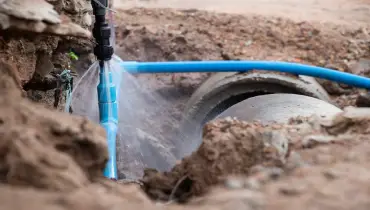 A broken water pipe that has been dug up leaks water. 