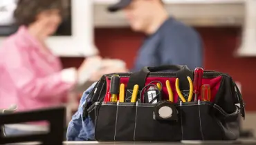 Repair main and woman talking behind tool bag