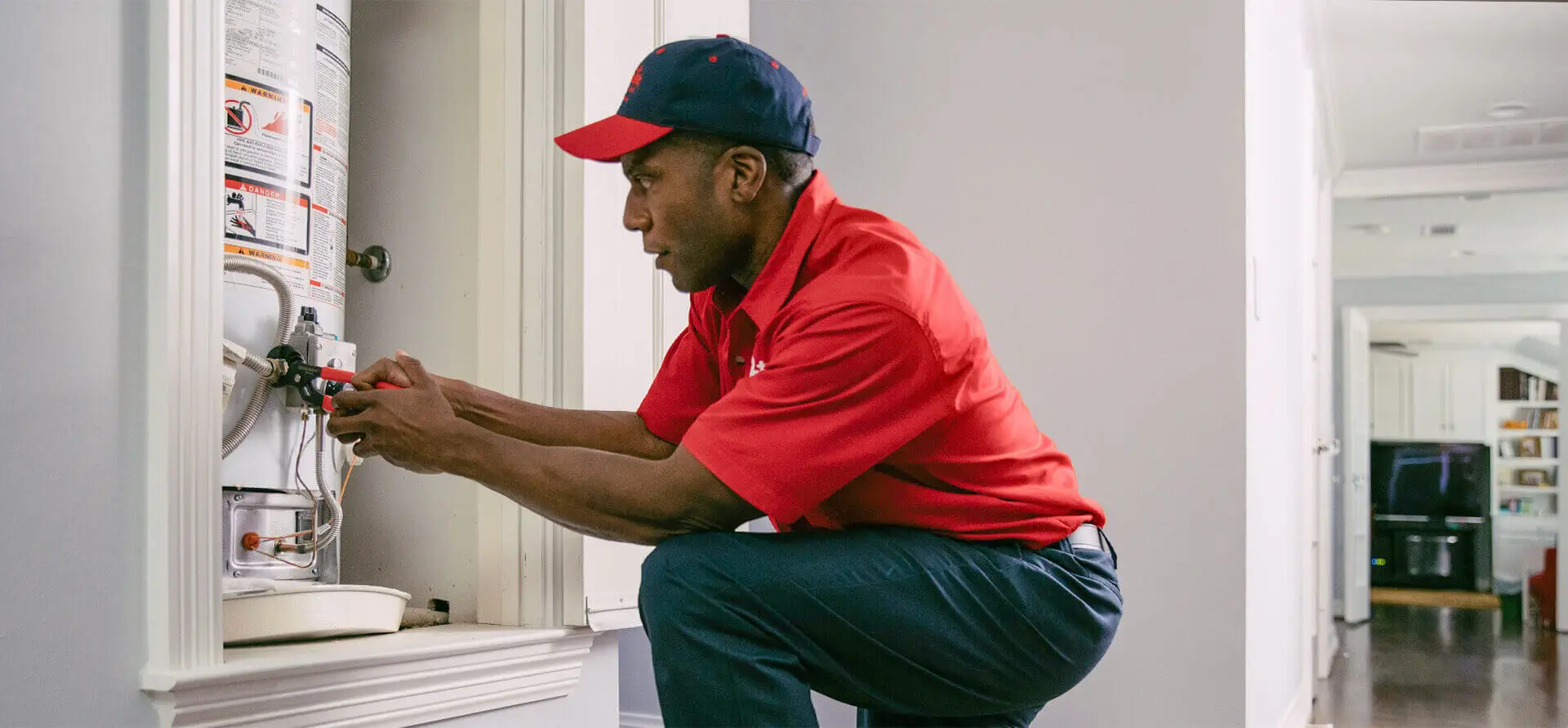 Mr. Rooter tech checking water heater in closet