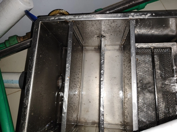 Top view of a dirty grease trap with water flowing | Mr. Rooter Plumbing of Southeast Georgia