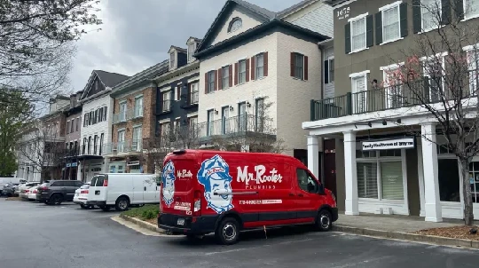 Mr. Rooter van in front of a row of businesses.