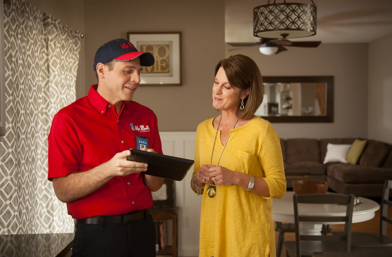 Mr. Rooter Plumber showing a tablet to a customer