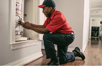 Mr. Rooter plumber repairing a water heater