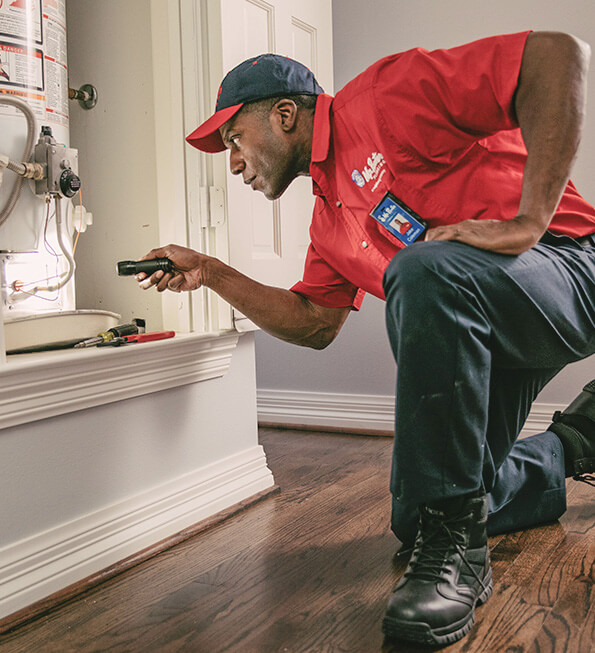 Mr. Rooter tech inspecting a water heater