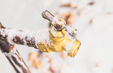 Snow covered outdoor spigot.