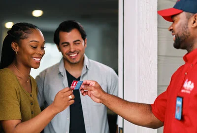 A courteous and uniformed Mr. Rooter Plumbing tech handling his business card to his customers