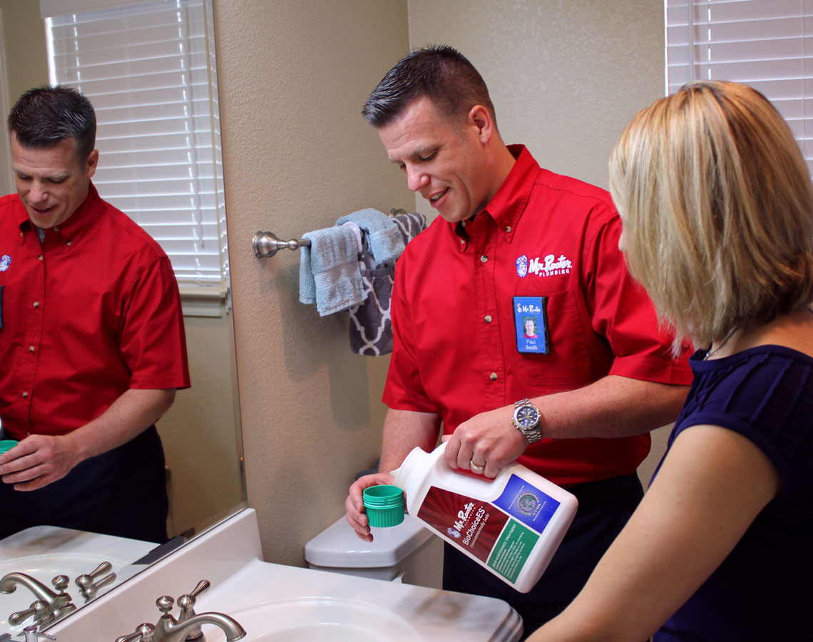 Mr. Rooter technician and customer standing at bathroom sink.