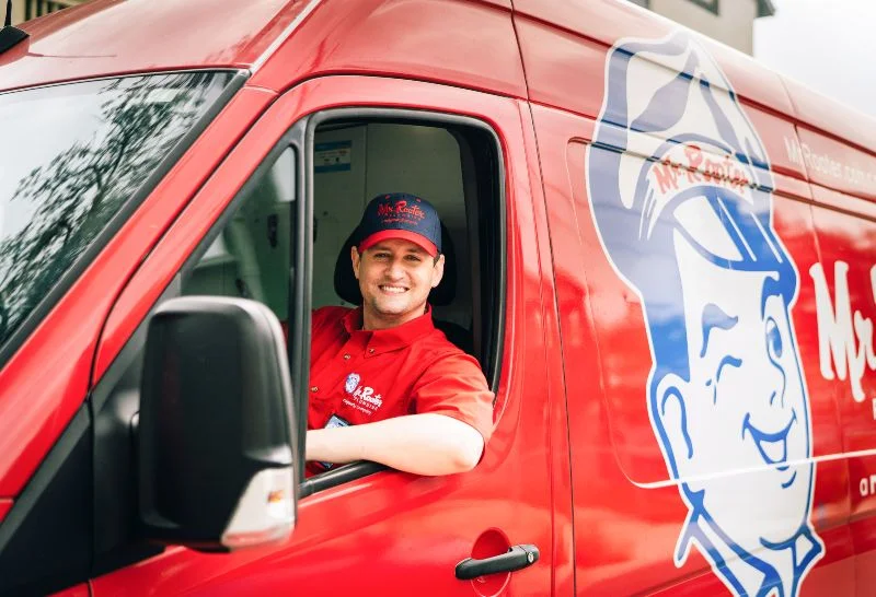 A Mr. Rooter plumber arriving to assist with plumbing repairs in Bedford, NH.