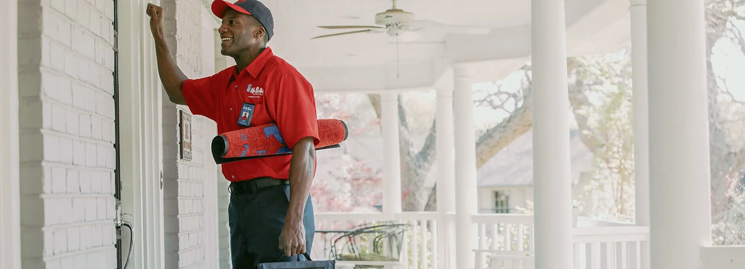 A Mr. Rooter plumber knocking on the door of a customer's home