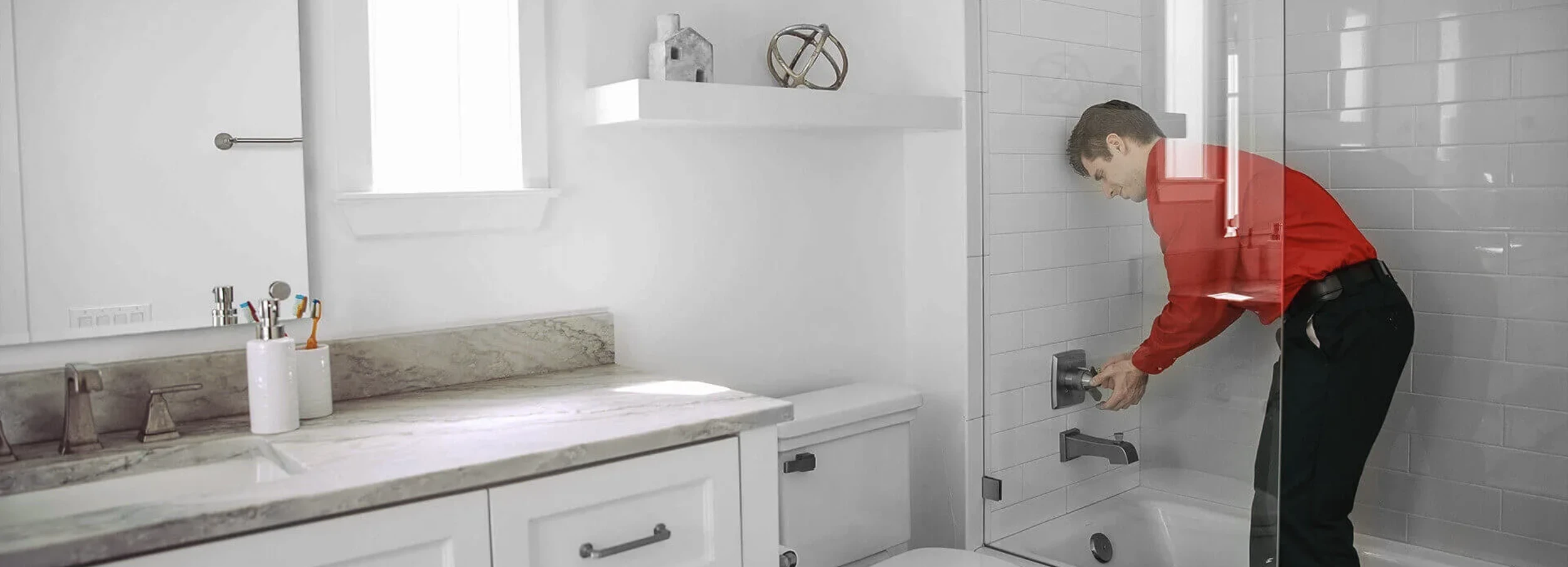 Mr. Rooter employee standing in shower turning handle