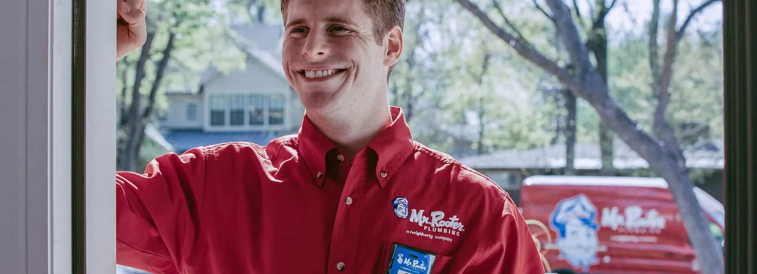 Smiling Mr. Rooter employee on customer's home.