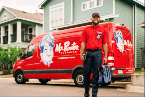 Mr. Rooter plumber holding video camera inspection equipment