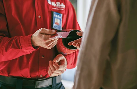 Mr. Rooter technician handing over business card to customer.