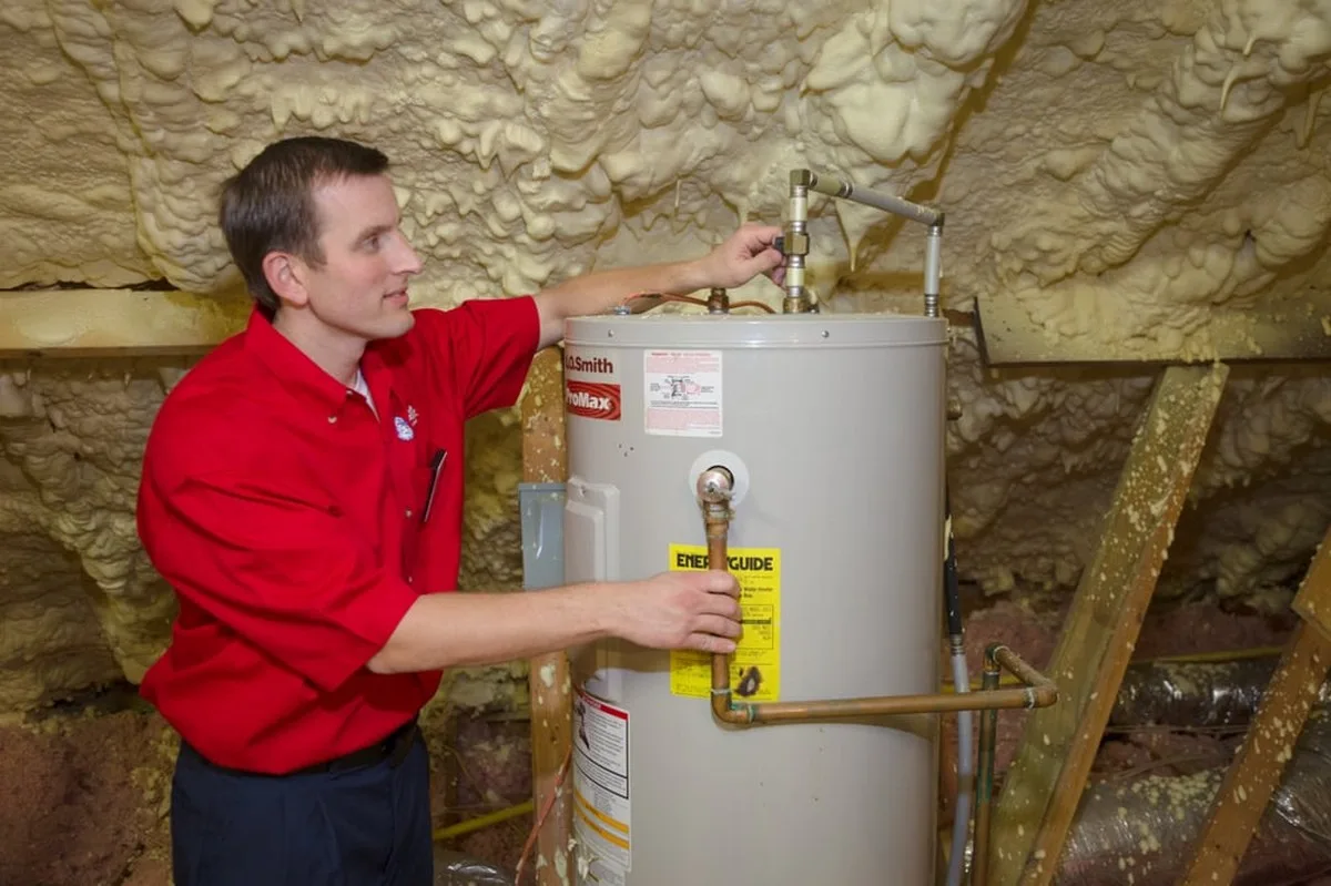 A Mr. Rooter plumber repairing a water heater