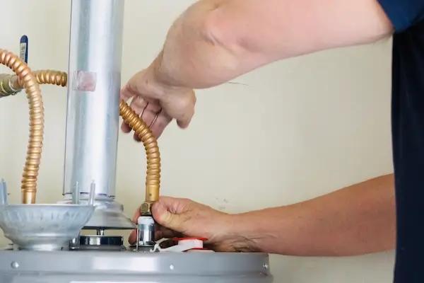 A service professional adjusting and tightening a commercial hot water heater 