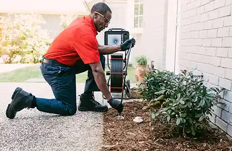 Mr. Rooter Plumber cleaning a drain.