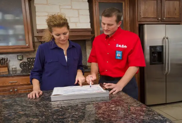 Mr. Rooter Plumbing technician discussing water heater installation options with Fort Worth homeowner