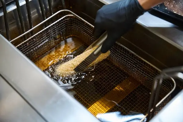 itchen worker deep-fries food in oil destined for commercial grease trap 