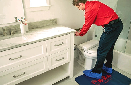 Mr. Rooter plumber in Manchester fixing a toilet