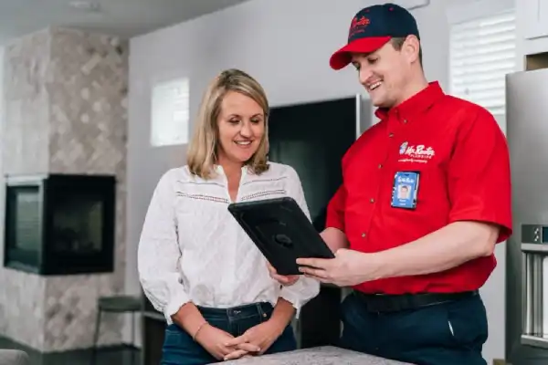 Mr. Rooter plumber discussing water softeners & filters with a woman