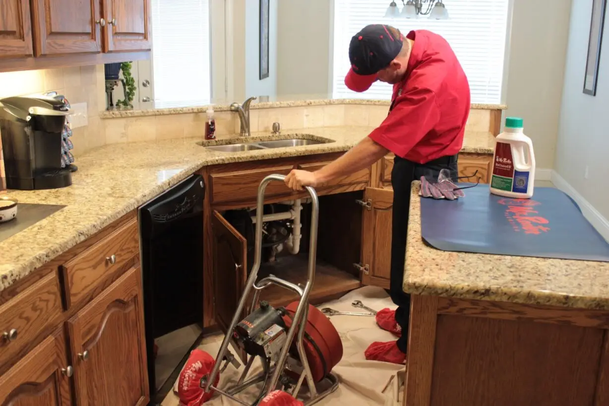 Mr Rooter employee cleaning drain