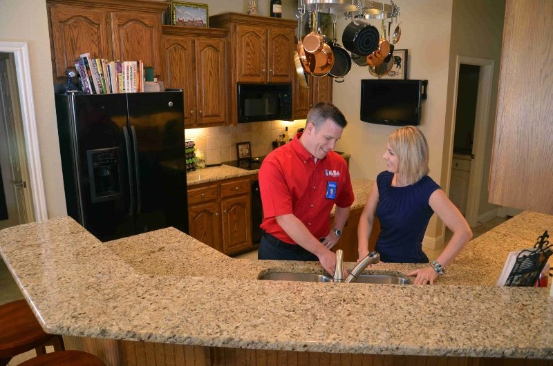 Plumber fixing clogged kitchen sink