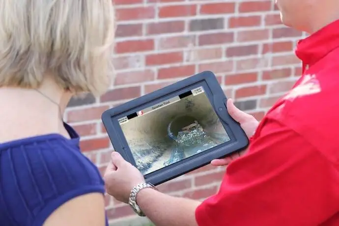 Mr. Rooter plumber inspecting sewer line with a camera