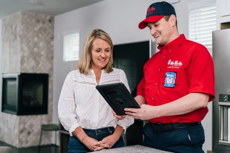 Mr. Rooter service professional discussing water softeners & filters with a woman