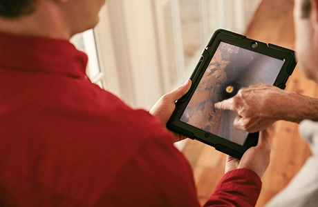 Wilmington emergency plumber showing a customer an image of a pipe on a tablet