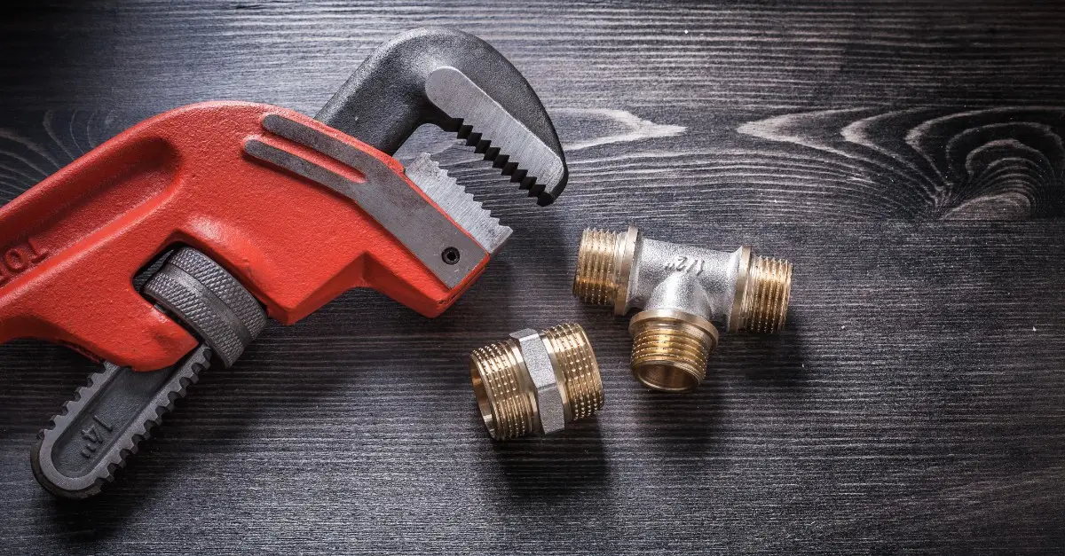 A wrench and pipe connectors used for water heater installation in Dallas, TX