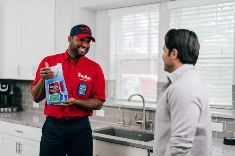 Mr. Rooter plumber discusses plumbing maintenance products with the customer.