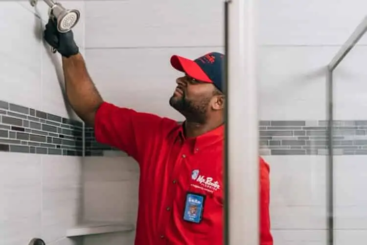 Mr. Rooter plumbing installing a showerhead.