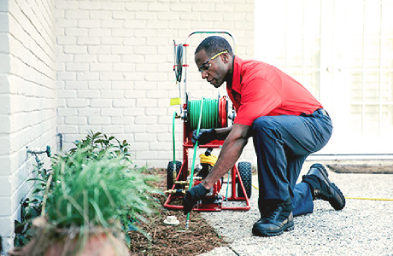 A Mr. Rooter Plumbing technician using a hydro jet to clean a sewer line