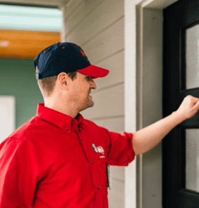 a Mr. Rooter plumber walking up to a house