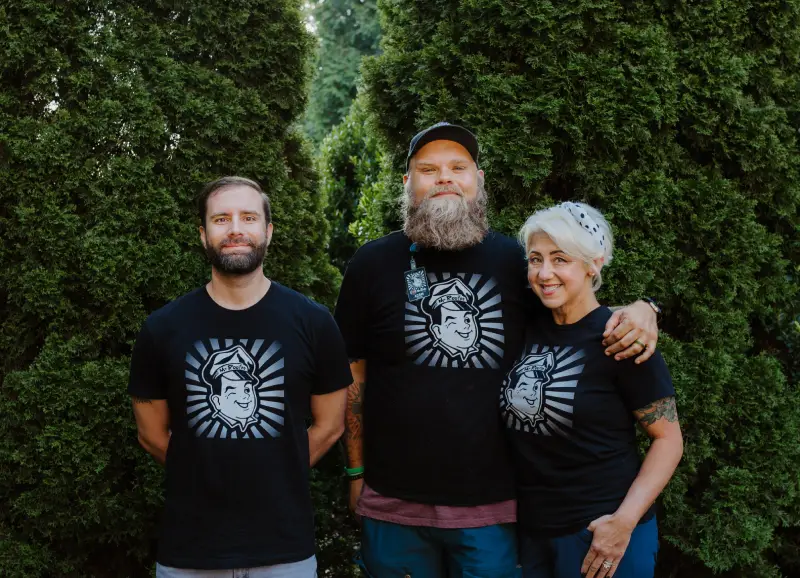 Mr. Rooter of Asheville employees wearing red Mr. Rooter shirts lined up for group photo with trees in the background, October 2017.