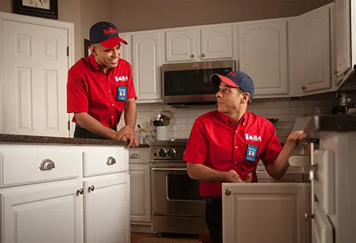 Mr. Rooter Plumbing specialist handing business card to a homeowner.