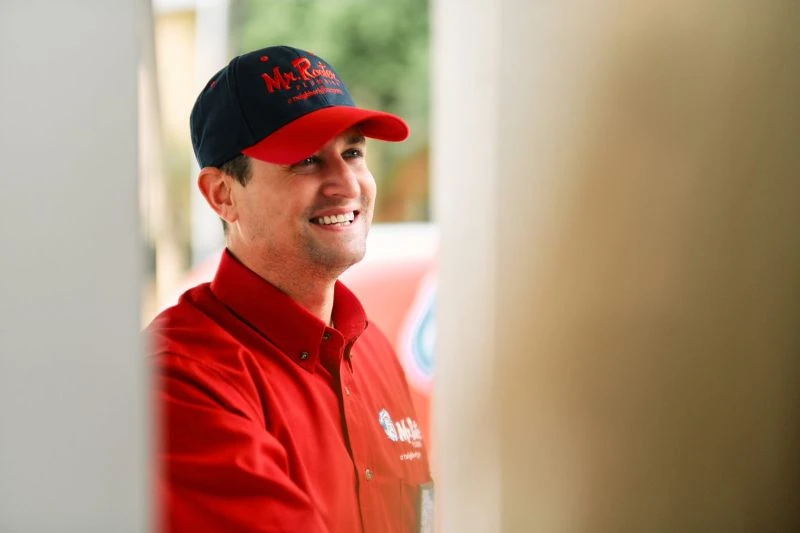 A Mr. Rooter plumber greeting a customer before a pipe insulation service in Olympia, WA